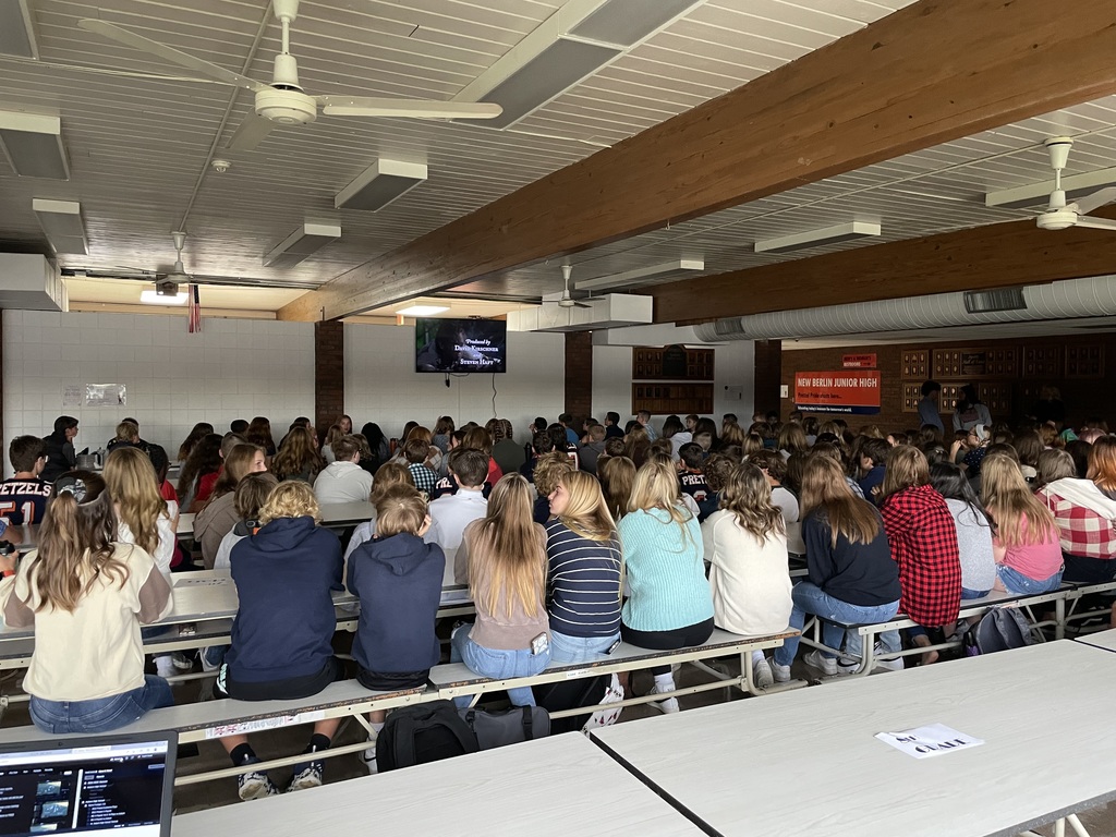 Students in cafeteria watching movie